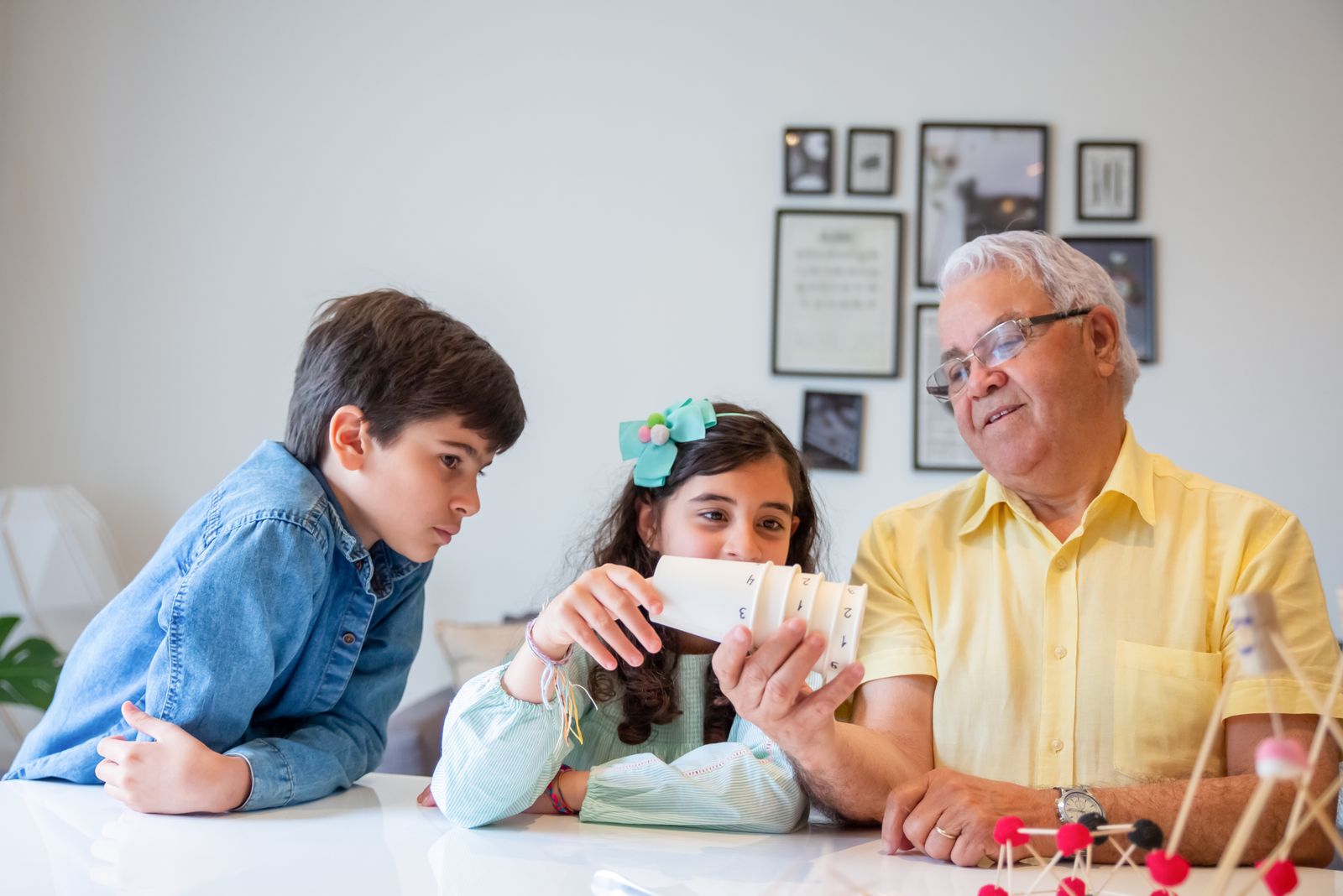 Two children and a grandparent looking at a phone together