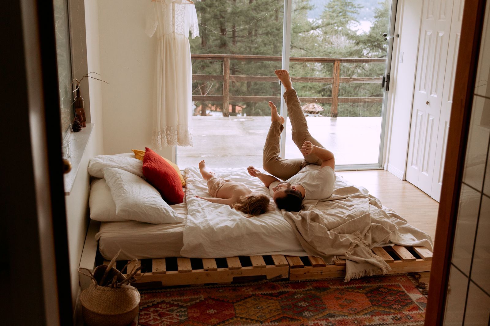 A child resting on a bed at home with a book